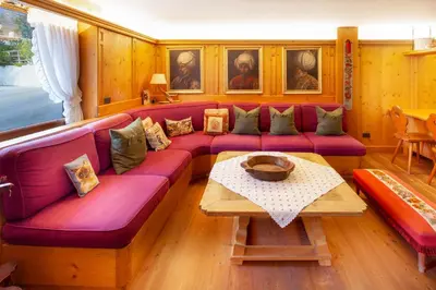 a living room with a purple couch and a table at Casa Marmorata in Cortina dʼAmpezzo