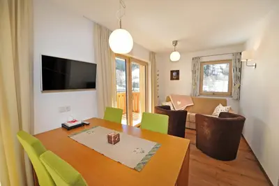 a living room with a dining room table and a living room at Apartments Cesa Leni in Bulla