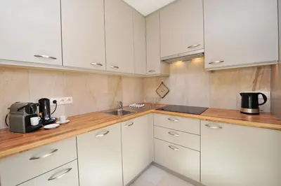 a kitchen with white cabinets and a sink at Apartments Cesa Leni in Bulla