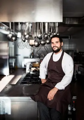 a man sitting on the counter in a kitchen at Sunnegg in Bressanone