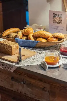 a table topped with baskets of bread and baskets of bread at Sunnegg in Bressanone