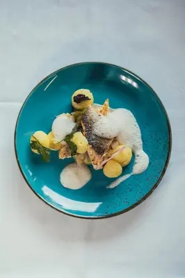 a blue plate with food on a white table at Sunnegg in Bressanone