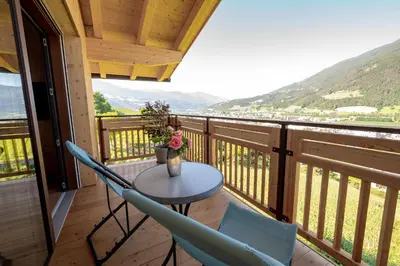 a table and chairs on a balcony with a view at Sunnegg in Bressanone