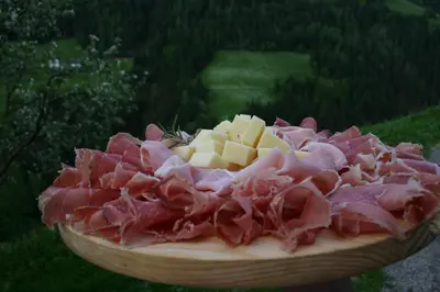 a plate of food with meat and cheese on it at Lüch da Grones in San Vigilio Di Marebbe