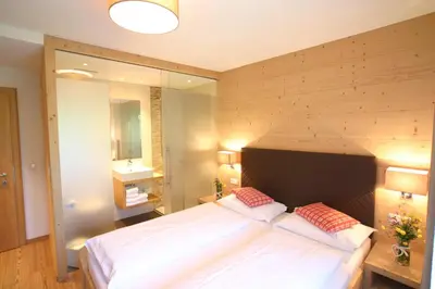 a bedroom with a large bed with a wooden headboard at Lüch da Grones in San Vigilio Di Marebbe