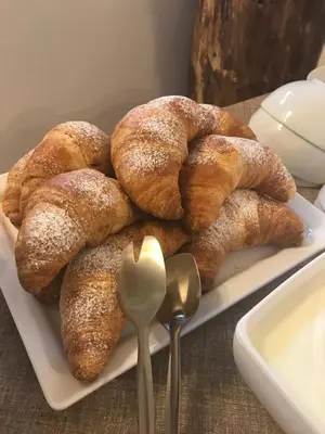 a plate of croissants on a table with spoons at Agritur Maso Piasina in Tesero