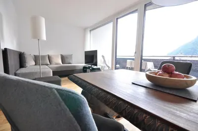 a living room with a table with a bowl of fruit on it at Alpenchalet Apartments in Parcines