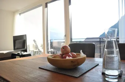 a bowl of apples on a table with a glass of water at Alpenchalet Apartments in Parcines