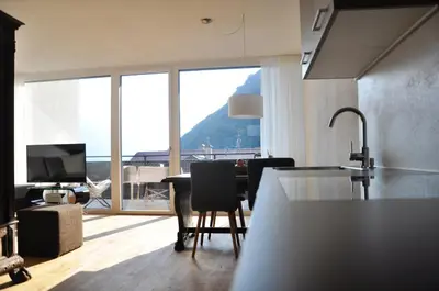a kitchen with a table and chairs and a large window at Alpenchalet Apartments in Parcines