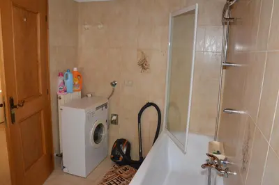 a bathroom with a shower and a washing machine at Appartamenti Vincenzo E Marcella in Campitello di Fassa