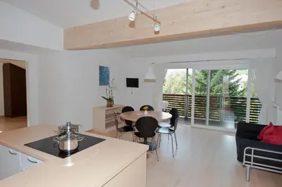 a kitchen and living room with a table and chairs at Appartements Margit in Vipiteno
