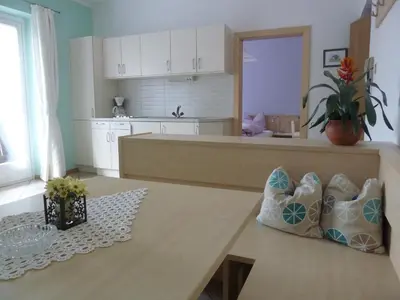 a living room with a table and a kitchen at Appartements Margit in Vipiteno
