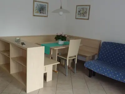 a dining room with a table and a blue chair at Appartements Margit in Vipiteno