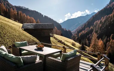 a table and chairs on a balcony with a view at Duner Heuschupfe in Fundres