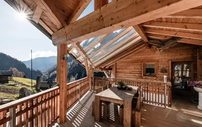 a wooden cabin with a table on a deck at Duner Heuschupfe in Fundres