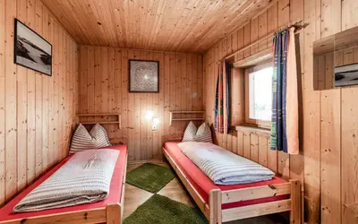 two beds in a room with wooden walls at Duner Heuschupfe in Fundres