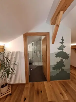a hallway with a glass door with a christmas tree on the wall at Duner Heuschupfe in Fundres