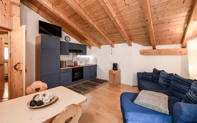 a living room with a blue couch and a table at Duner Heuschupfe in Fundres