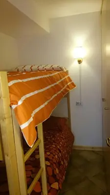 a bunk bed in the corner of a room at Rododendro Apartment in Passo San Pellegrino