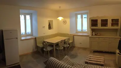 a kitchen with a table and chairs in a room at Appartamento il Nido in Moena