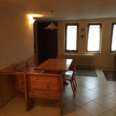 a dining room with a wooden table and chairs at Appartamento il Nido in Moena