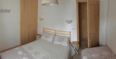 a bedroom with a bed and a closet with a door at Appartamento il Nido in Moena