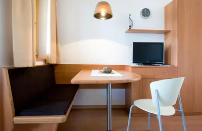 a small room with a table and a chair and a television at Pschoalhof in Lana