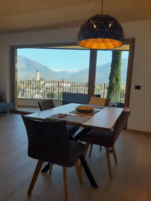 a dining room with a table and a large window at Pschoalhof in Lana