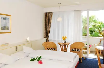 a hotel room with two beds and a table and chairs at Kröllnerhof in Lana