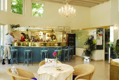 a restaurant with tables and chairs and a counter at Kröllnerhof in Lana
