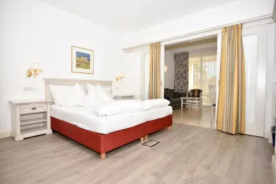a bedroom with a large bed and a living room at Kröllnerhof in Lana