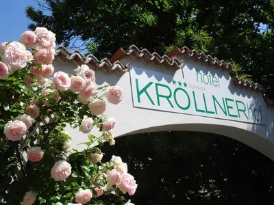a sign for a hotel kroniner with pink flowers at Kröllnerhof in Lana