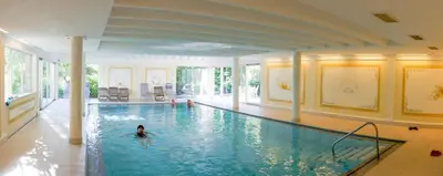 a person swimming in a large swimming pool at Kröllnerhof in Lana