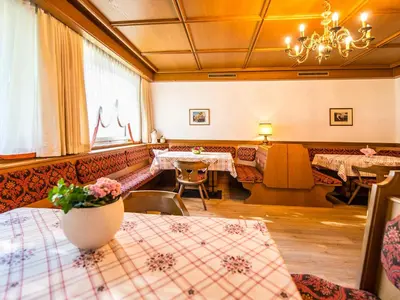 a dining room with tables and a chandelier at Pension Lahn in Rablà