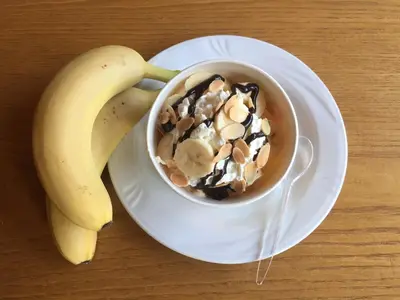 a banana sitting on a plate next to a cup of coffee at Pension Lahn in Rablà