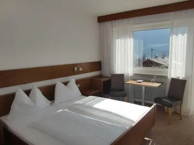 a hotel room with a large bed and a window at Pension Lahn in Rablà