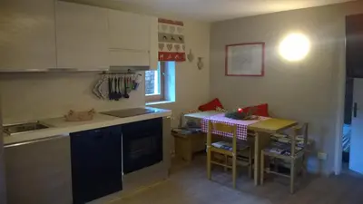 a small kitchen with a table and a counter top at Chalet Do Costa in Pozza di Fassa