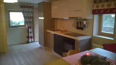 a kitchen with a table and a stove top oven at Chalet Do Costa in Pozza di Fassa