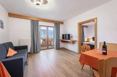 a living room with a couch and a bed and a table at Georgenhöhe in Lana