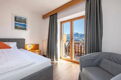 a bedroom with a bed and a couch and a window at Georgenhöhe in Lana