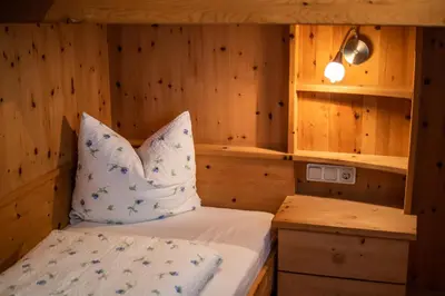 a room with a bed in a wooden cabin at Apartment ARGENTIS Krumas-Living - Kronplatz in San Vigilio Di Marebbe