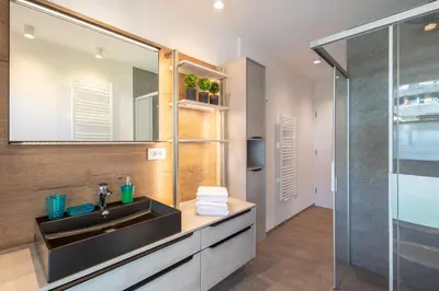 a bathroom with a sink and a glass shower at Apartment ARGENTIS Krumas-Living - Kronplatz in San Vigilio Di Marebbe