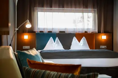 a bedroom with a bed with white pillows and a window at ALIA appartements & wellness in Lagundo