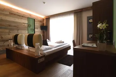 a hotel room with a bed and a desk at ALIA appartements & wellness in Lagundo