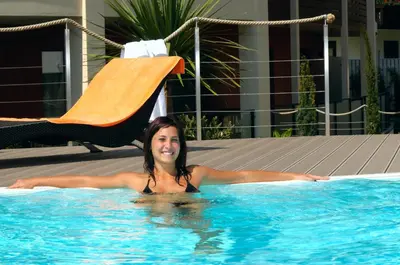 a woman laying in a swimming pool at ALIA appartements & wellness in Lagundo