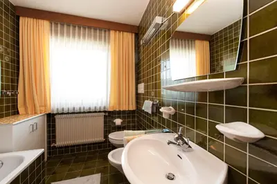 a bathroom with two toilets and a sink at Ciasa Saina in La Valle