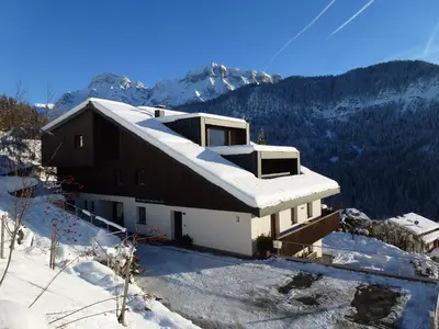 a table and chairs sitting on a field with a view of a mountain at Ciasa Saina in La Valle