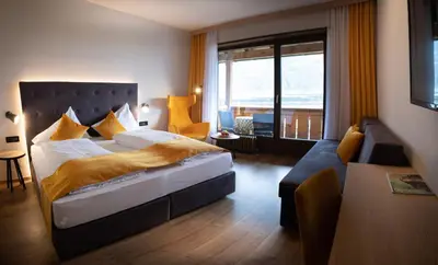 a hotel room with a bed and a couch at Hotel und Residence Johanneshof in Cermes