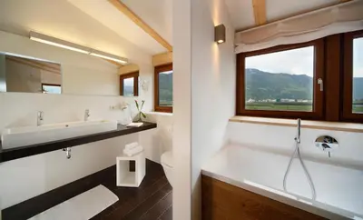 a bathroom with a tub and a sink and a window at Hotel und Residence Johanneshof in Cermes
