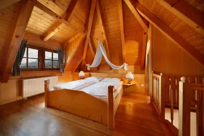 a bedroom with a bed in a wooden house at Hotel und Residence Johanneshof in Cermes